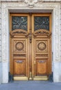 Antique double door entrance of old building in Paris France. Vintage wooden doorway and stucco fretwork wall. Royalty Free Stock Photo