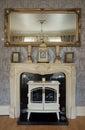 Antique fireplace  in the home with clock & mirrors on the mantlepiece Royalty Free Stock Photo