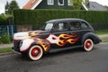 An antique Ford De Luxe Sedan car painted in fiery colors. Ford Motor Company introduced its De Luxe Ford line in 1938. Berlin