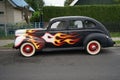 An antique Ford De Luxe Sedan car painted in fiery colors. Ford Motor Company introduced its De Luxe Ford line in 1938. Berlin
