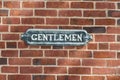 Antique gentlemen sign on red brock