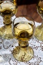 Antique German glassware, old Dutch style rummer or roemer glasses with white wine on white lace tablecloth Royalty Free Stock Photo