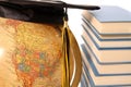 Antique globe, graduation cap and books