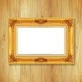 Antique gold frame on wooden wall ;. Empty picture frame on whit Royalty Free Stock Photo