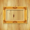 Antique gold frame on wooden wall ;. Empty picture frame on whit Royalty Free Stock Photo