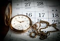 An antique gold pocket watch lies on calendar sheets Royalty Free Stock Photo