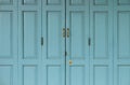 Antique golden Doors locked on blue old door.