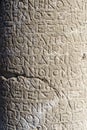 Antique greek inscriptions carved on the stone of the old ruins of an antique greek city