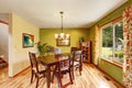 Antique green dining room interior with mahogany table set and chandelier.