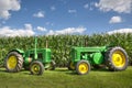 Antique Vintage Green John Deere Tractors in front of a corn field with a blue sky. Royalty Free Stock Photo