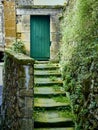 Antique green wooden door at the end of a stone staircase Royalty Free Stock Photo