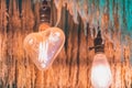 Antique heart shaped light bulbs hanging with green and gold color dried ear of rice to decorate in the coffee shop. Selective