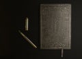 Antique homemade embossed books with fountain pens and fake pirate coins