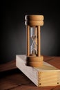 Antique HourGlass Time on wood block with dark background Royalty Free Stock Photo