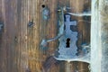 An antique iron door handle with a keyhole on a wooden door Royalty Free Stock Photo