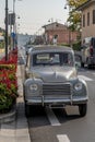 An antique Italian model car parked along a city street