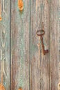 An antique key hanging on the wall on a nail on an old rough wooden wall Royalty Free Stock Photo