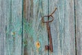 An antique key hanging on the wall on a nail on an old rough wooden wall Royalty Free Stock Photo