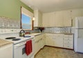 Antique kitchen interior with white cabinets and green wall.