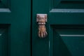 antique knock door shape hand on green door. Southern Italy Royalty Free Stock Photo