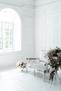 Antique light sofa in front of a white wall near the window,