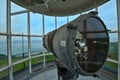 An antique lighthouse light inside the tower stands guard over the coastline Royalty Free Stock Photo