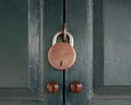 Antique locked with old rusted padlock on green door.