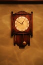 Antique looking pendulum wooden wall clock Royalty Free Stock Photo