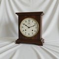 Antique mantel clock with a rectangular dark wood case. The clock face is circular, Royalty Free Stock Photo