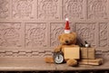 Antique Mantelpiece with a teddy bear in a New Year's hat, and an invitation envelope,alarm clock, a fir branch, a gift