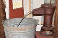 Antique manual hand water pump and bucket of water