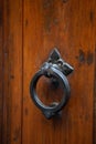 Antique metal doorknob circle shaped on brown front door. Vintage round handle on wooden entrance door. Close up shot