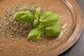 Antique metallic dish with dried and fresh basil.