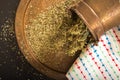 Antique metallic dish and pot with dried oregano.