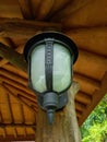 Antique and minimalist garden lamp with white mirror and black stalk. Low angle and front view