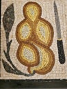 Antique mosaic with the image of bread and a knife.