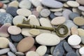 Antique old brass key on beach stones Royalty Free Stock Photo