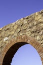 Antique, old monument ruin arch architecture made with rocks and bricks with blue sky in the background