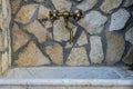 Antique old plumbing tap in a stone wall Royalty Free Stock Photo