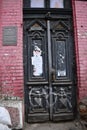 Antique ornate door and architectural details of dilapidated building with red brick wall