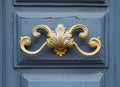 antique ornate gold door handle on a blue wall Royalty Free Stock Photo