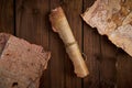 Antique parchment scroll with old maps on a wooden table. Royalty Free Stock Photo