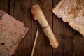 Antique parchment scroll with old maps on a wooden table. Royalty Free Stock Photo