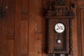 Antique pendulum clock hanging on the wooden wall Royalty Free Stock Photo
