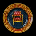 Antique plate depicting a chair on a black background.