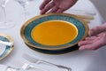 Antique plate filled with carrot soup being served on elegant table set with beautiful antique silverware Royalty Free Stock Photo