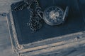 Antique pocket fob watch with a chain on a stack of old books.  On a wooden background Royalty Free Stock Photo