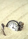 Antique pocket watch buried in sand Royalty Free Stock Photo