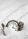 Antique pocket watch buried in sand. Royalty Free Stock Photo