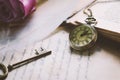 Antique pocket watch and old vintage key with vintage tone